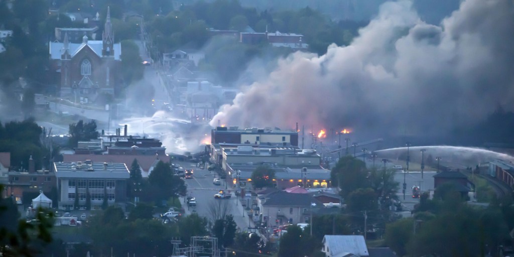 Firefighters douse blazes after a freight train loaded with oil derailed in Lac-Megantic in Canada's Quebec province.