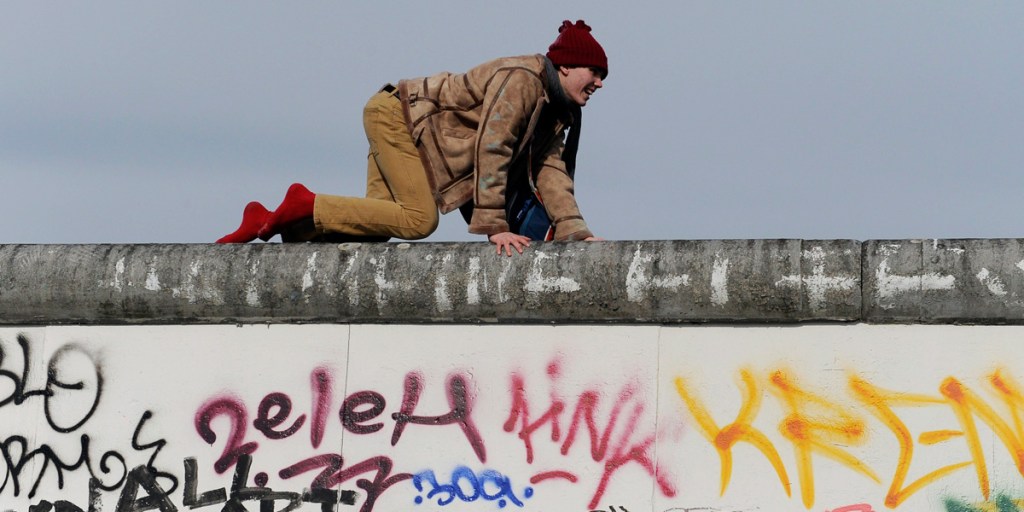 A demonstrator crawls on the East Side Gallery, a piece of art and part of the former Berlin Wall, in March this year. Protesters want to prevent the dislocation of parts of the memorial to make room for a building project.