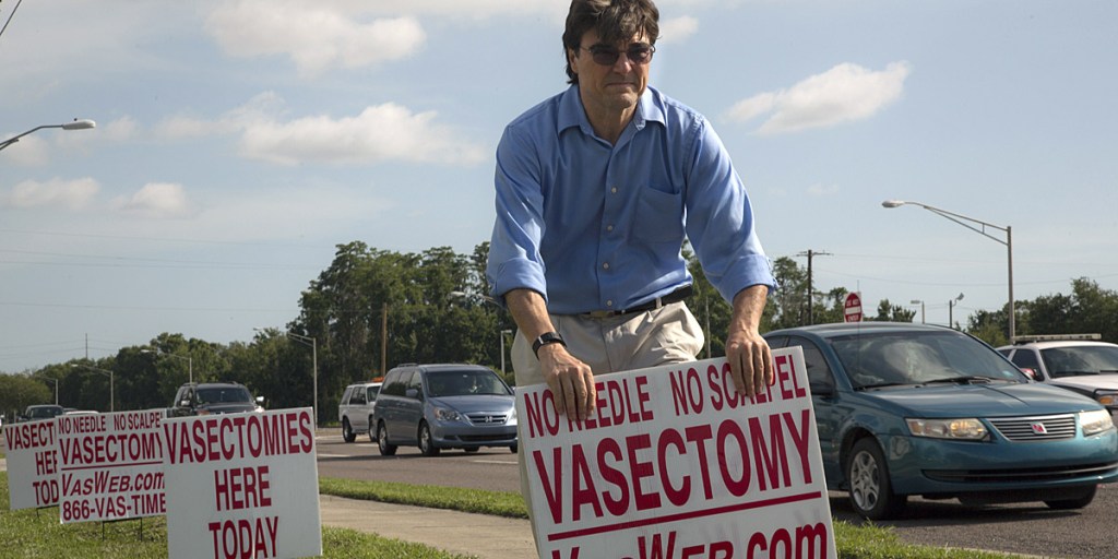 Dr Doug Stein putting up a roadside sign in The Vasectomist.