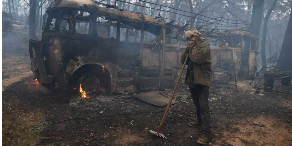Sean Butler stands in front of his 1958 bus after fighting a fire with five other residents at the historic township Newnes Junction, north of Lithgow.