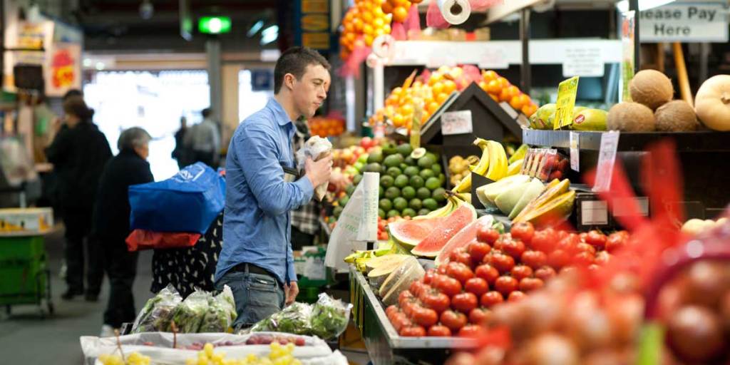 A shopper selecting fresh produce at the Adelaide Central Market. Photo: Nat Rogers/InDaily