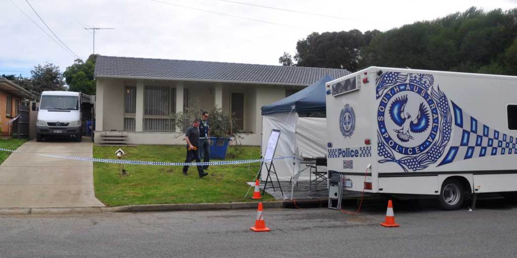 Police search the backyard of a house, previously lived in by a former suspect in the disappearance of Louise Bell, in July 2012.