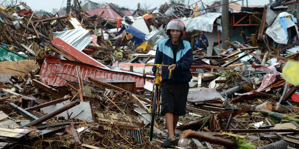A man among the extraordinary destruction wreaked by Typhoon Haiyan.