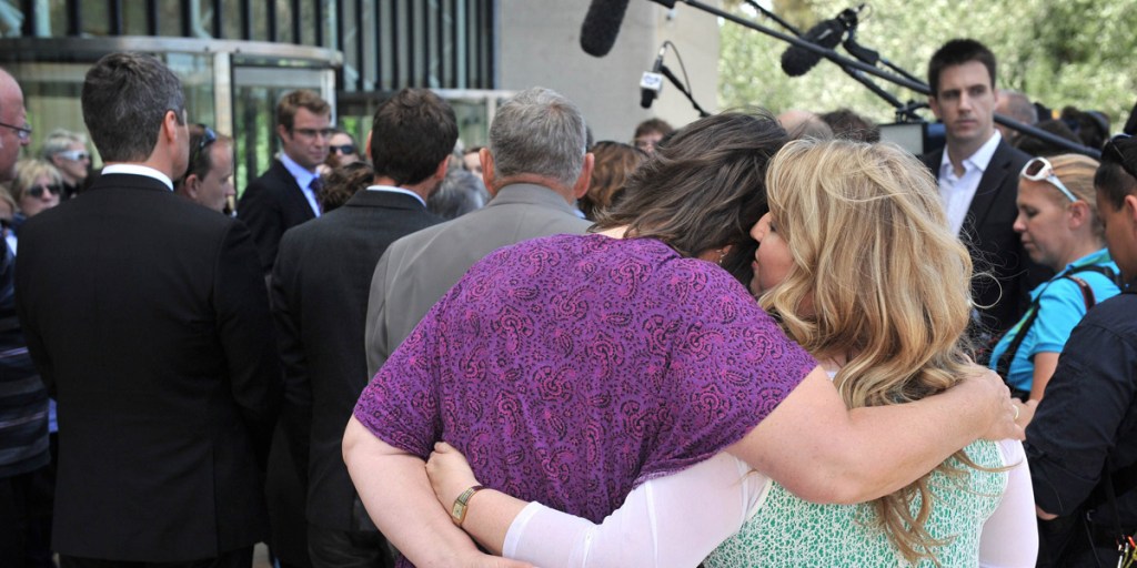 A couple hug outside the High Court in Canberra yesterday.