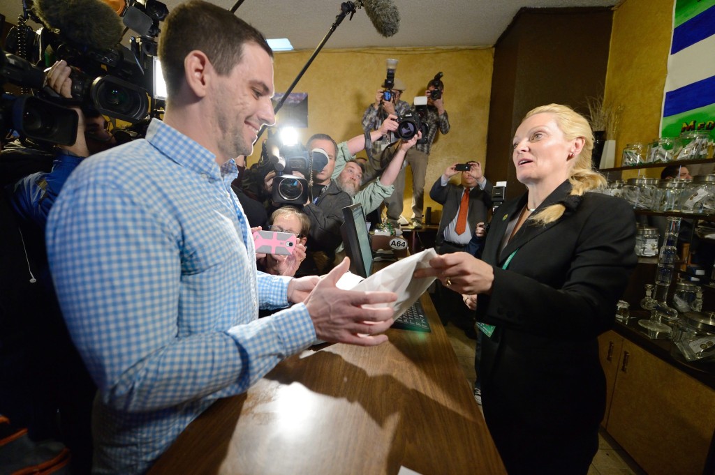 Media record the first legal marijuana sale at the Denver Discreet Dispensary in Colorado
