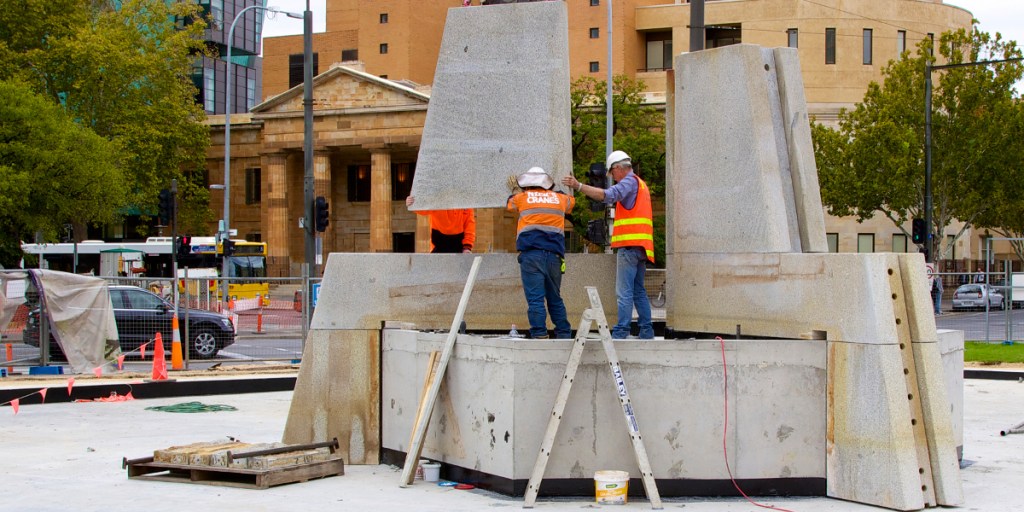 Workers reconstruct Three Rivers Fountain at Victoria Square's southern end.