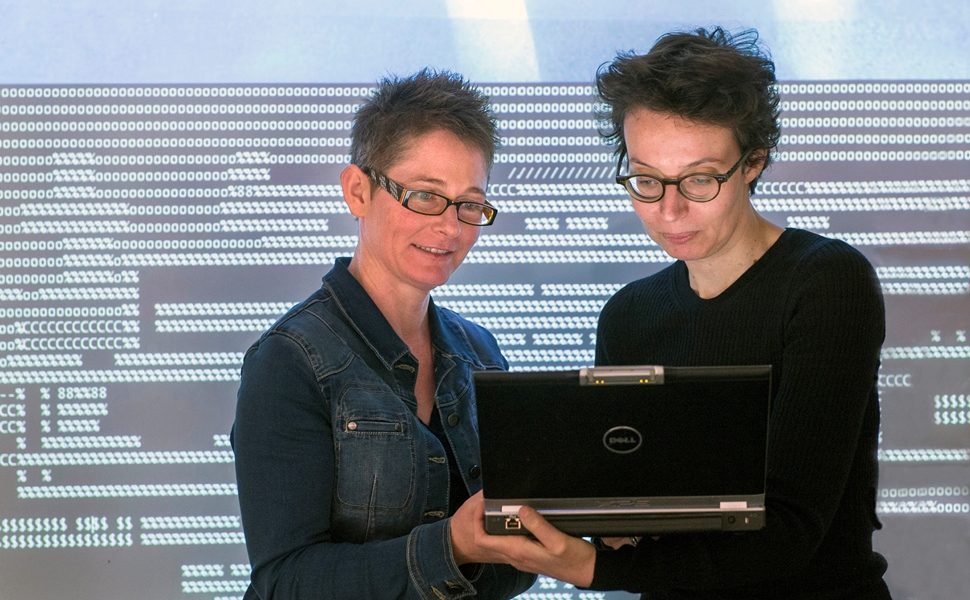 Associate Professor Melanie Swalwell and Dr Anne Laforet  (l-r) viewing the digital artwork OSS/•••• 