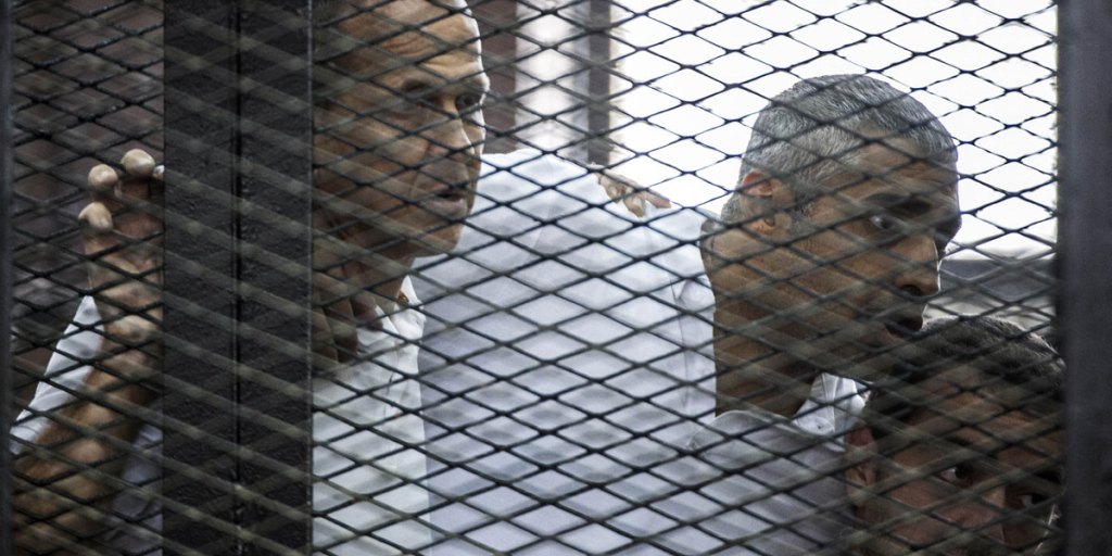 Australian journalist Peter Greste (left) listens to his trial verdict with colleagues Mohamed Fadel Fahmy (centre) and Baher Mohamed.