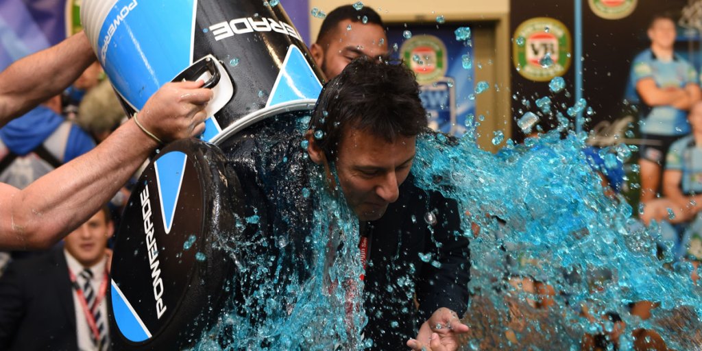 NSW coach Laurie Daley gets a celebratory shower after his team broke Queensland's long state of origin winning streak.