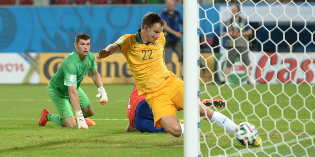 Australia's Alex Wilkinson slides in to clear the ball off the line in the Socceroos first match, against Chile.