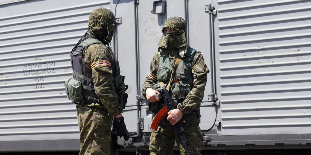 Armed rebels guard coaches that carry the bodies of the victims of Malaysia Airlines flight MH17. Photo: AAP