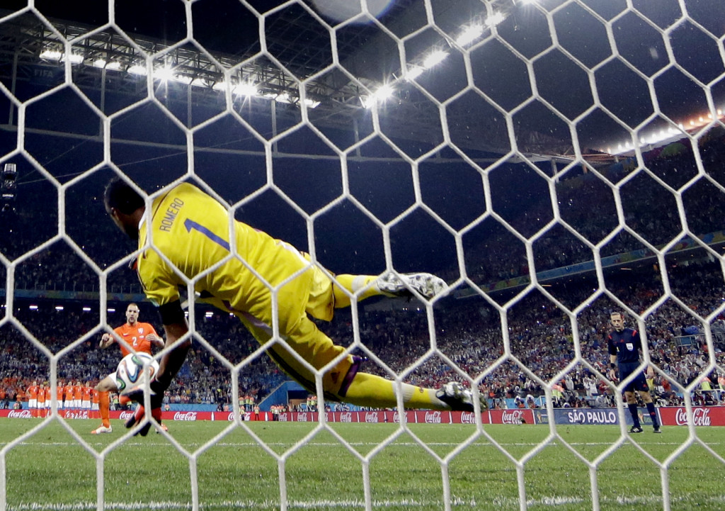 Argentina's goalkeeper Sergio Romero blocks a shot by Netherlands' Ron Vlaar during a penalty shootout