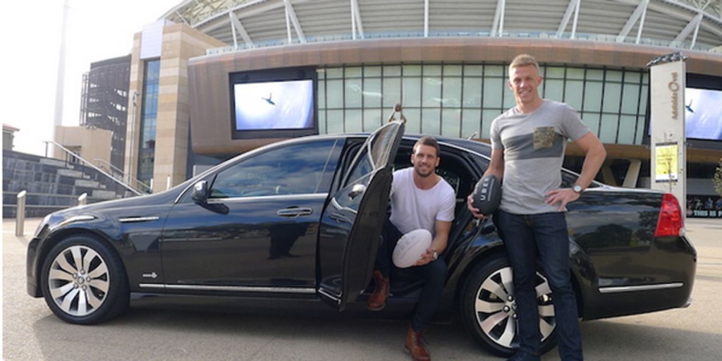 Port Adelaide captain Travis Boak and Crows' skipper Nathan van Berlo in an Uber promotion.