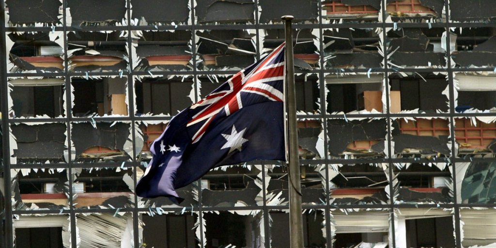 The Australian flag waves in front of a damaged building near the Australian embassy in Jakarta on Thursday, 09 September 2004. 