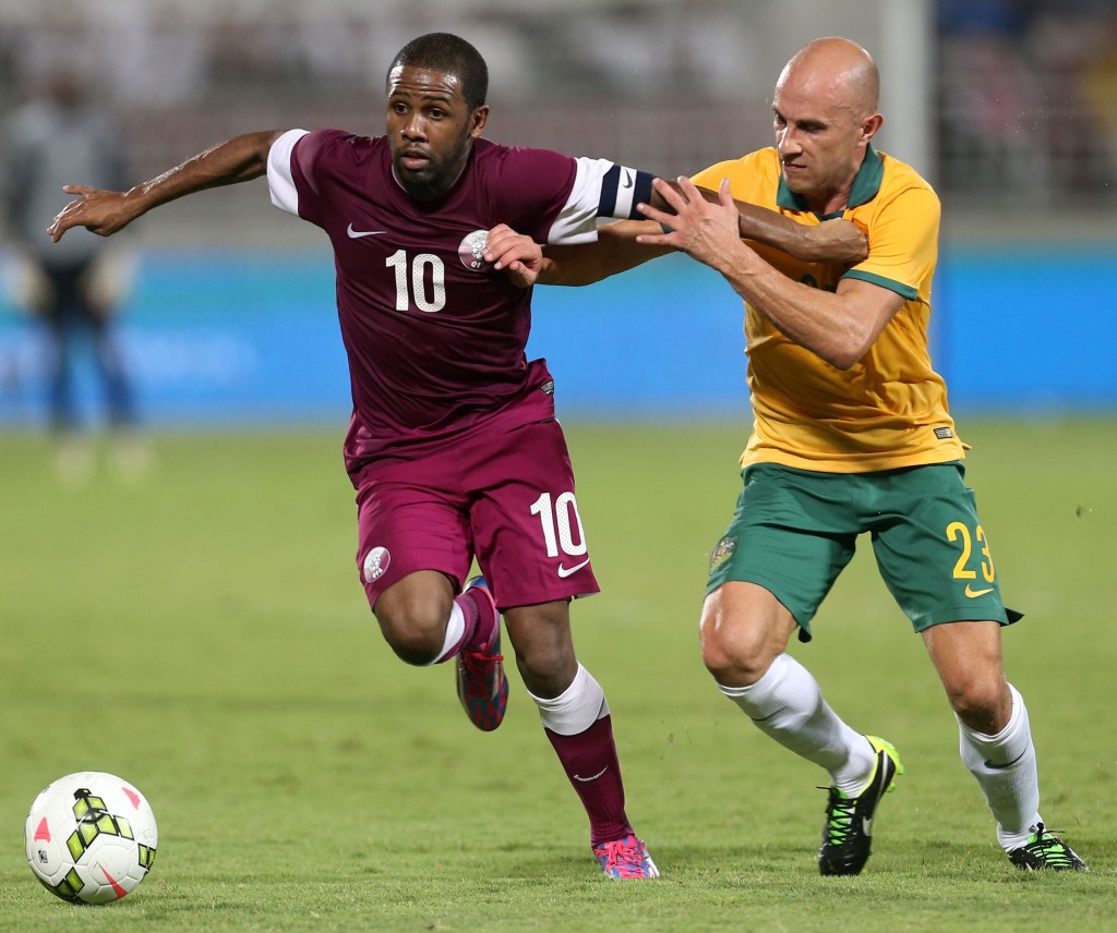 Mark Bresciano fends off  Qatar's Ibrahim Khalfan