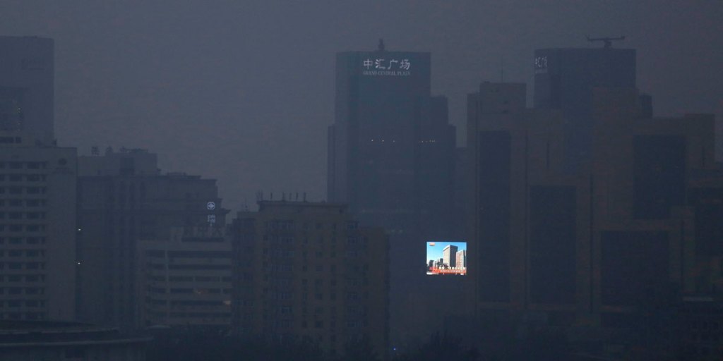 Light in the darkness: an illuminated billboard shines through the smog in Beijing.