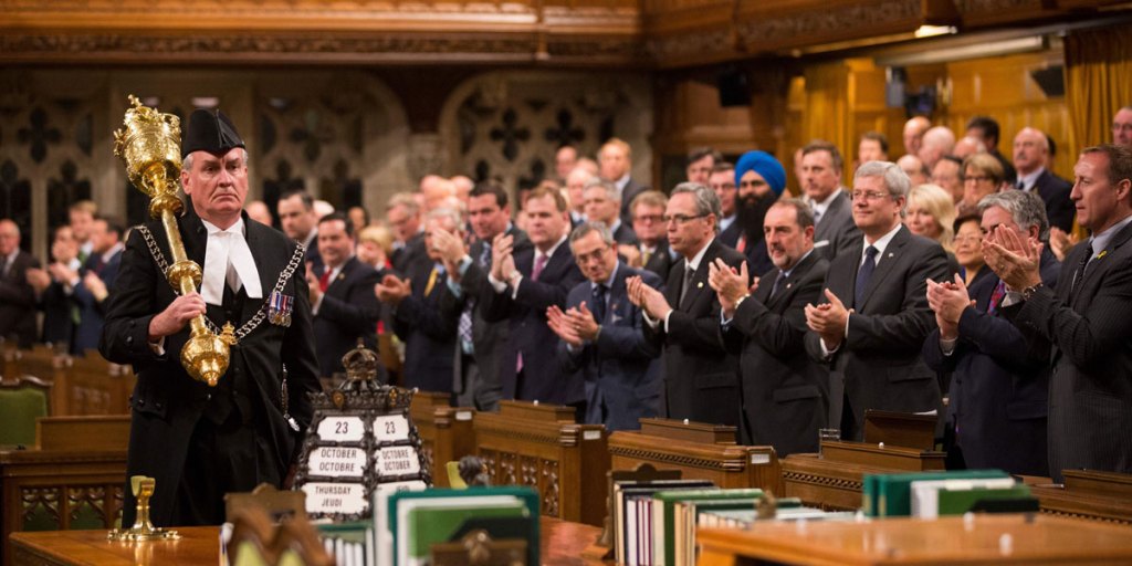 Members of the Canadian Parliament applaud Kevin Vickers, Sergeant-at-Arms.