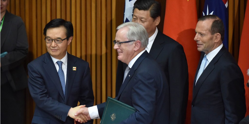 Chinese Commerce Minister Gao Hucheng shakes hands with Australian Trade Minister Andrew Robb after the signing of the free trade agreement. Photo: AAP