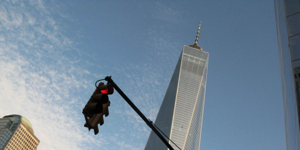 The One World Trade Center stands tall above other nearby buildings.