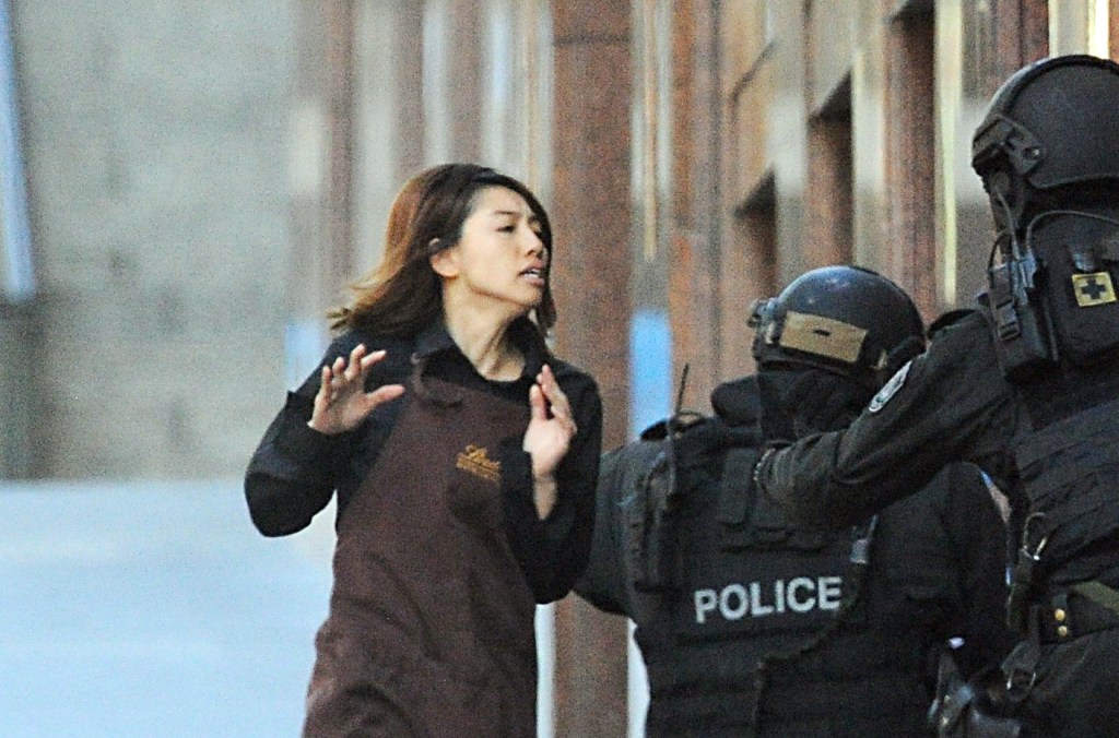A hostage runs into the arms of Police after leaving the Lindt Chocolat Cafe in Sydney.