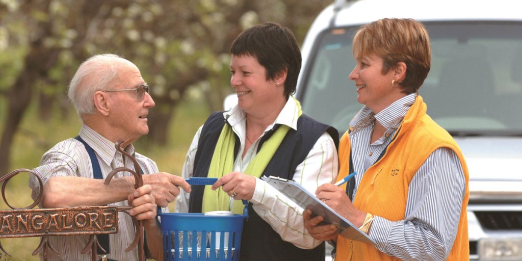 South Australian Meals on Wheels volunteers exchanging a meal and chat with a rural client.