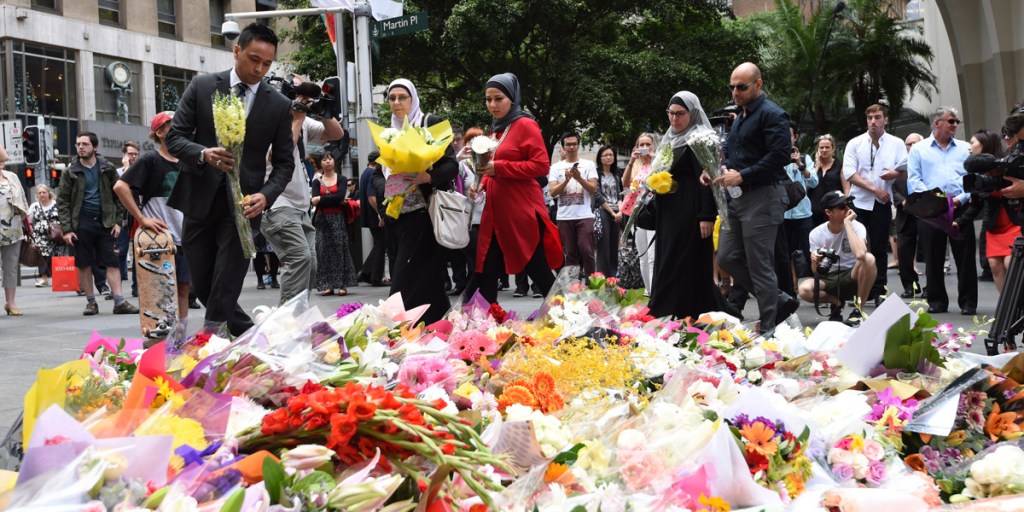 Muslim community members lay flowers near the Lindt chocolate cafe in Martin Place following the siege. Photo: AAP 