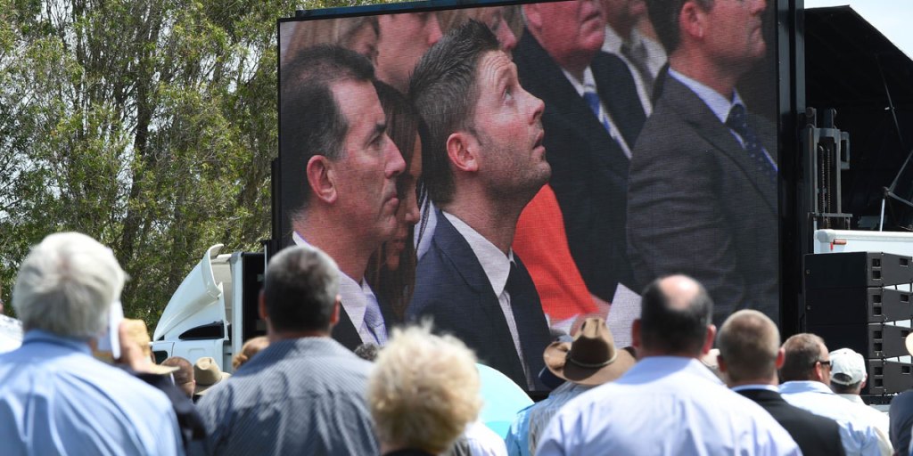 Test captain Michael Clarke on the big screen, as mourners watch Phillip Hughes' funeral in his home town of Macksville.