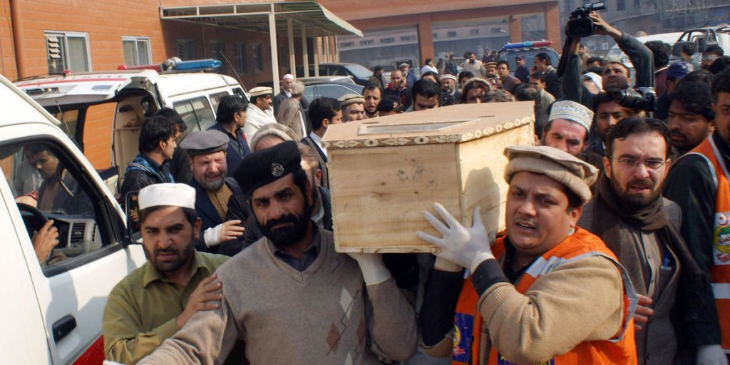 Volunteers carry the coffin of a student killed in a Taliban attack on a school in Peshawar.