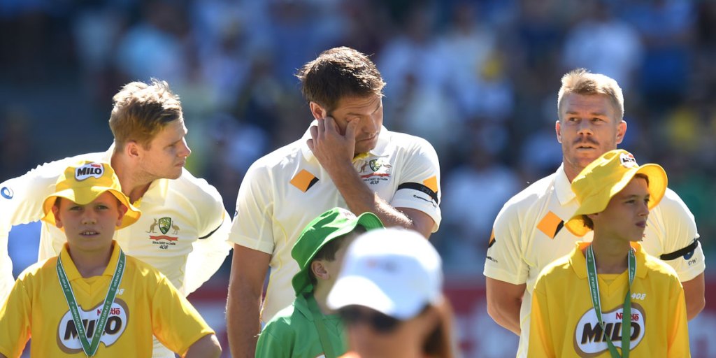 From left; Steve Smith, Ryan Harris and David Warner stand during a tribute to the late Phillip Hughes before play.