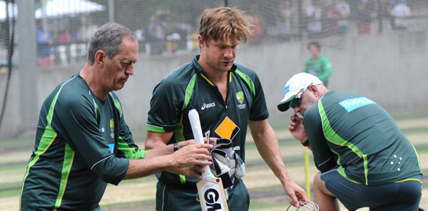 Team doctor Peter Brukner helps Shane Watson as he leaves the nets, while coach Darren Lehmann (right) looks on.