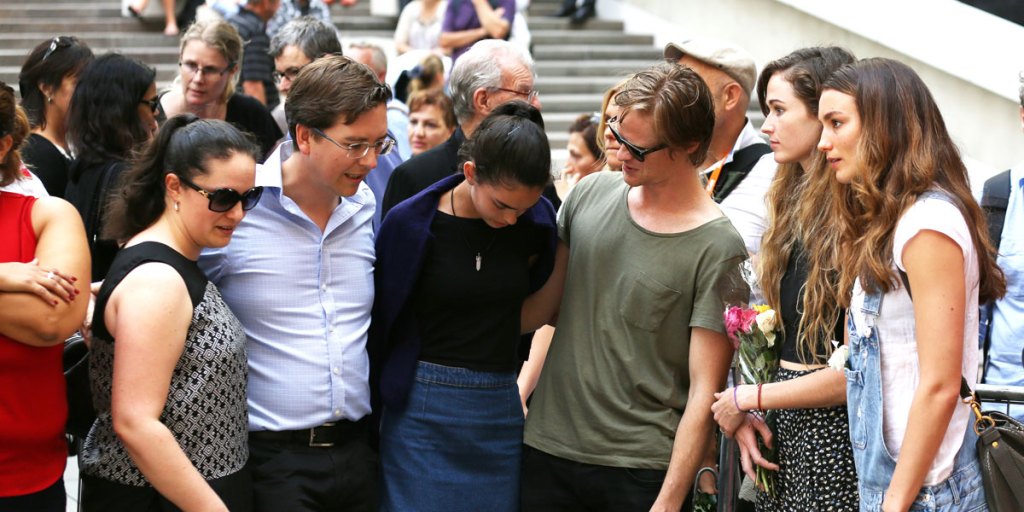 Thomas Zinn (second from left) the partner of siege victim Tori Johnson joins family members at the tribute at Martin Place.