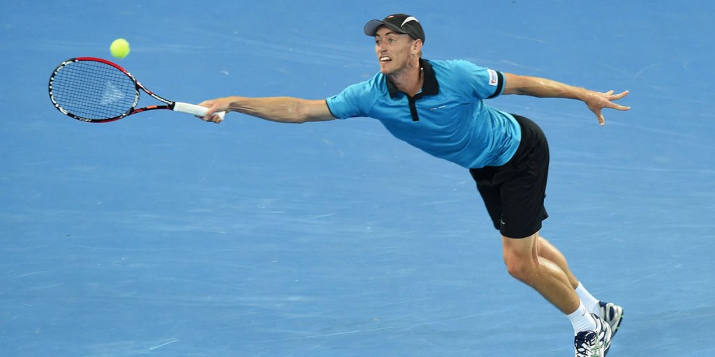 Millman stretches for a return against Federer.