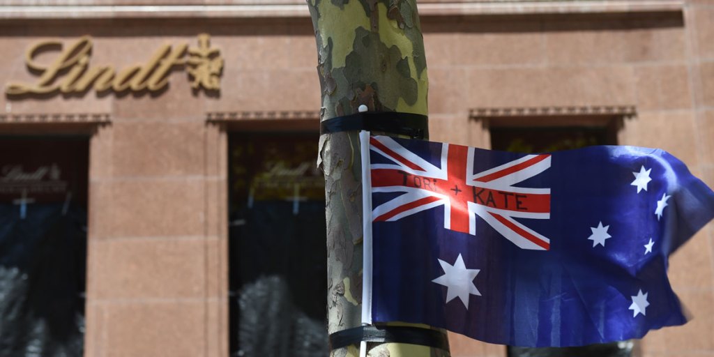A flag blows in the wind bearing the names of siege victims Tori Johnson and Katrina Dawson at a memorial outside the Lindt Cafe in Sydney in December.