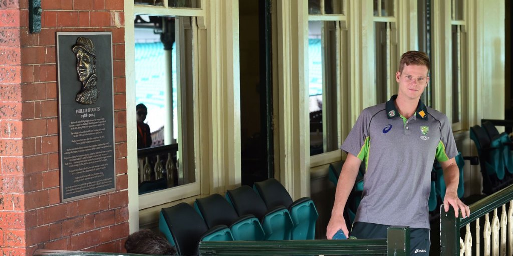 Australian cricket captain Steve Smith walks past a plaque remembering Phillip Hughes, mounted in the Member's Stand at the SCG.
