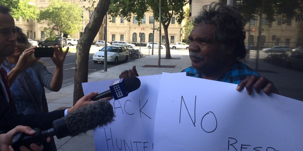 APY Chairperson Owen Burton calls for Ian Hunter to be sacked outside the State Administration building today.