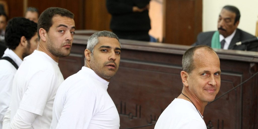 Peter Greste (right) during his trial, with fellow journalists Mohammed Fahmy (centre) and Baher Mahmoud (left).