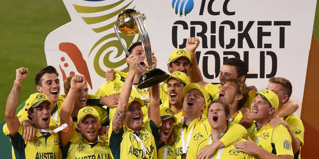 Michael Clarke holds aloft the World Cup trophy, surrounded by his jubilant teammates.