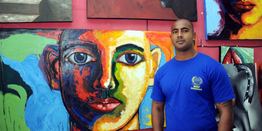Condemned Australian drug smuggler Myuran Sukumaran stands in front of his paintings in Kerobokan prison.