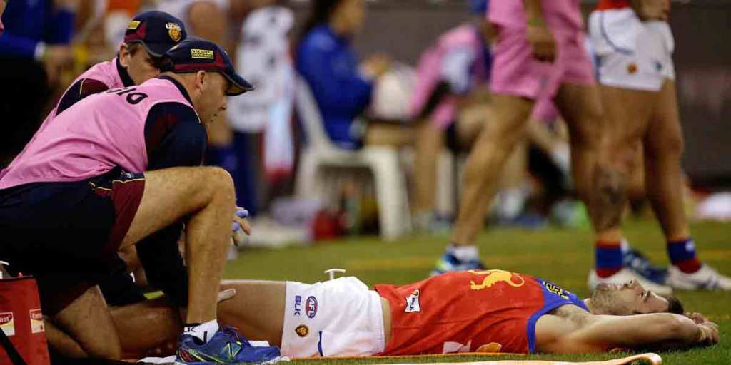 Michael Close being assessed on the sidelines at Etihad after injuring his knee.