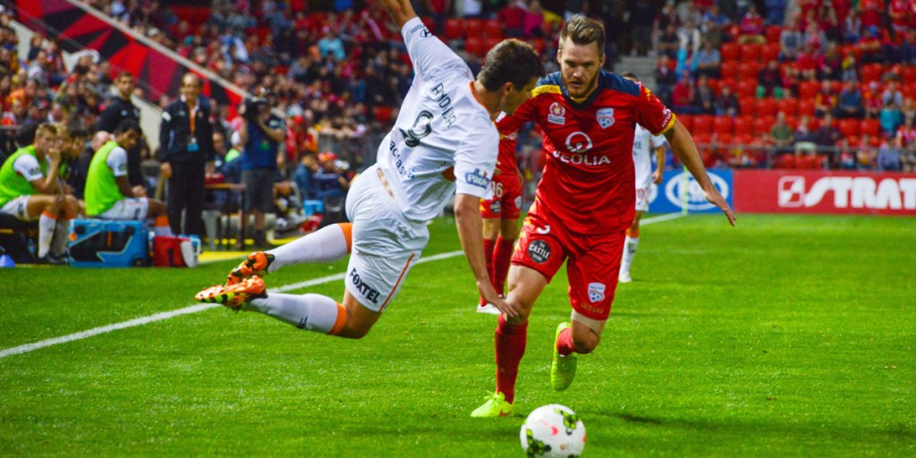 Brisbane's Andrija Kaludjerovic (left) tackles Adelaide's Nigel Boogaard during the round 25 A-League match against Adelaide United.