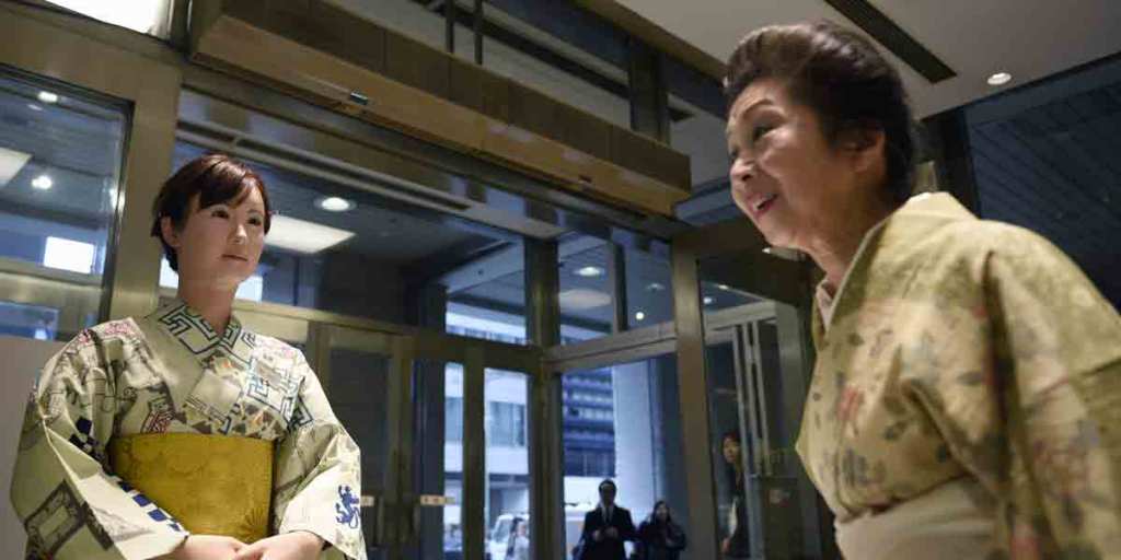 A kimono clad woman with a humanoid robot who started a two-day stint this week welcoming customers at a high-end Tokyo department store.