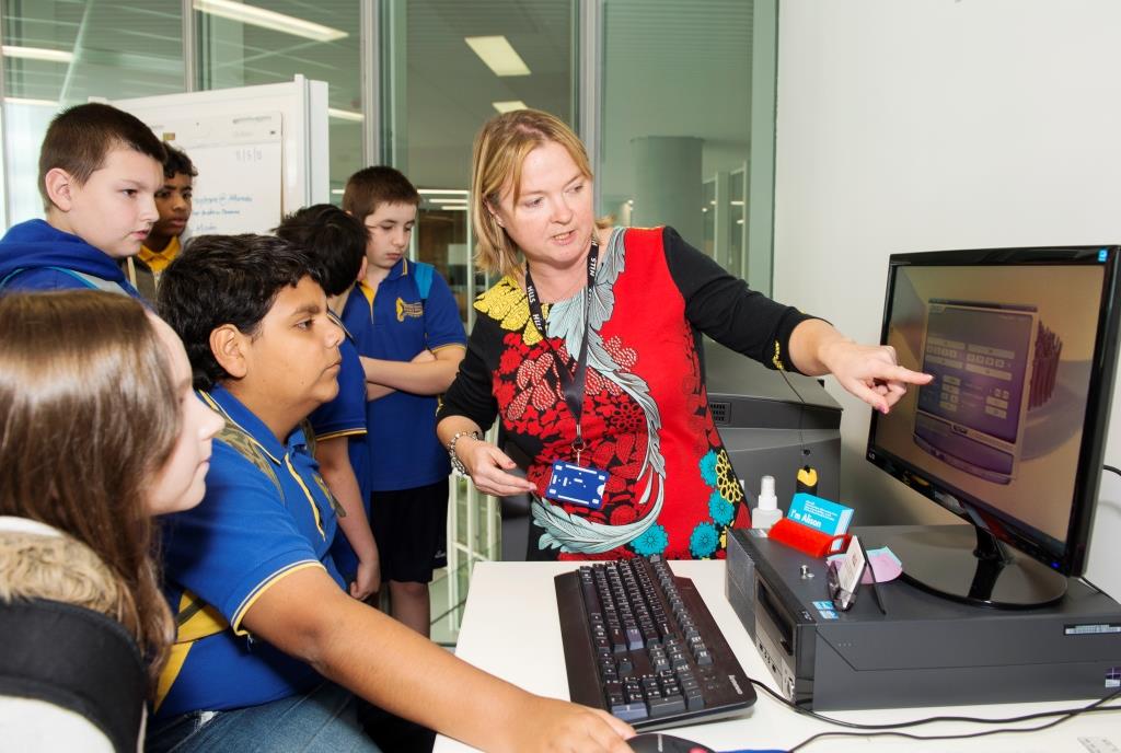 Hills Project Coordinator Alison Gill works with Christie Downs school students on their 3D printing project.