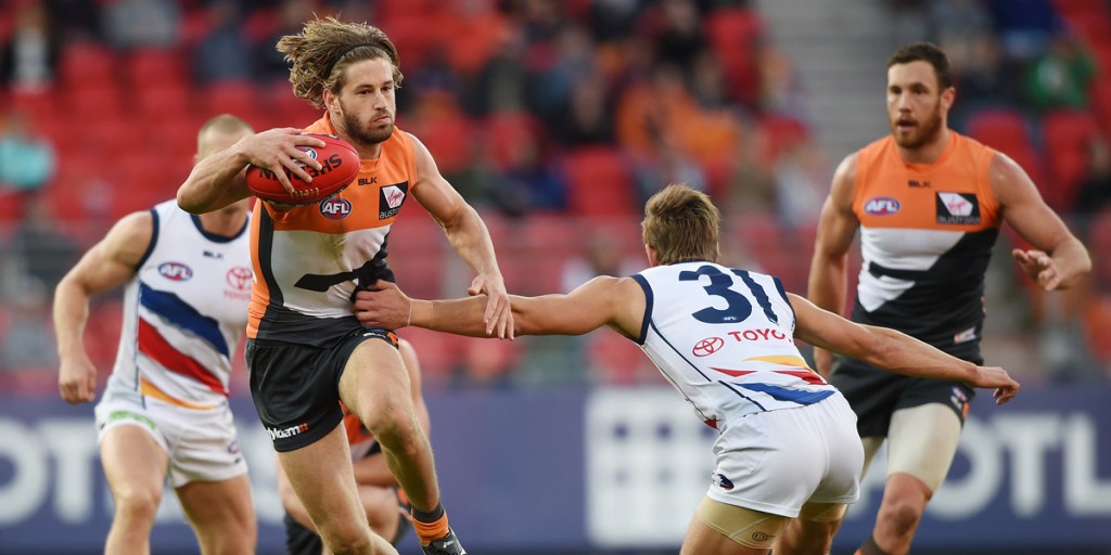 Callan Ward of the Giants scoots past Adelaide's Jarryd Lyons. AAP image