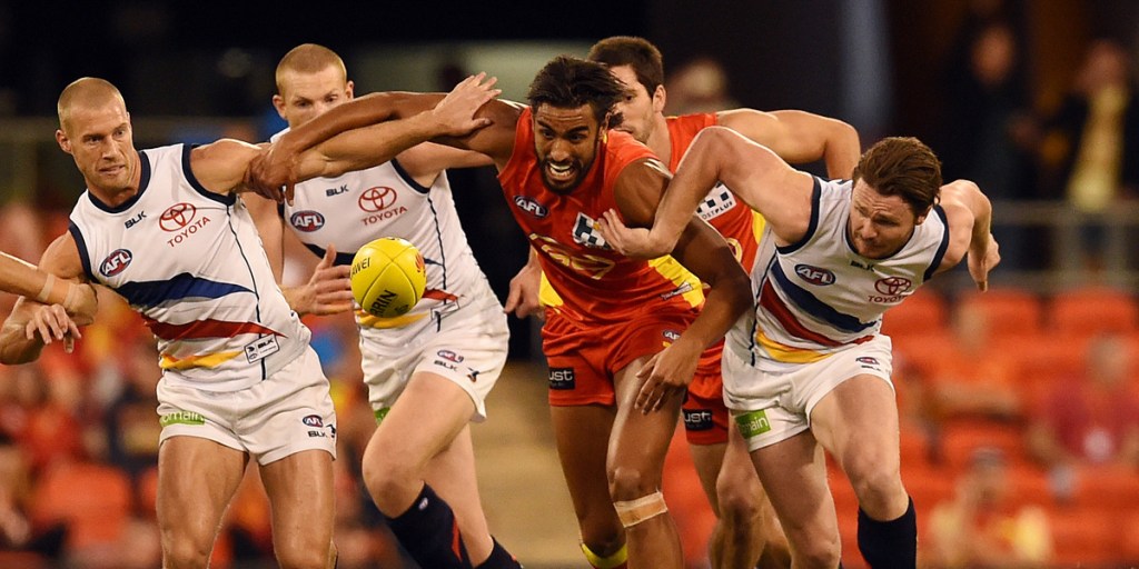Gold Coast's Tom Nicholls surrounded by Crows. AAP image