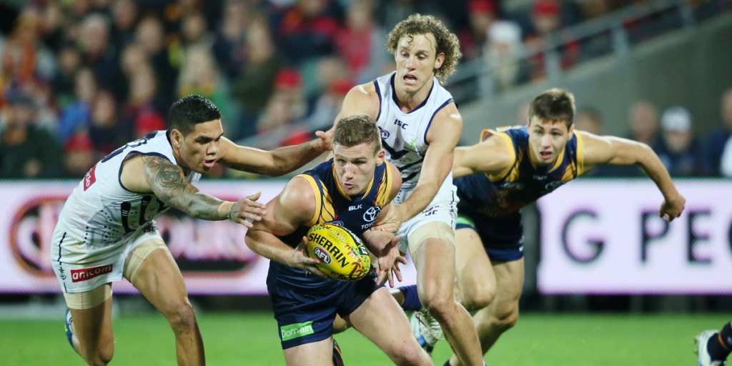 Rory Laird beats two Dockers to the ball at Adelaide Oval. 