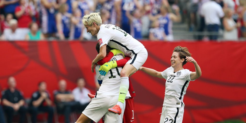 Carli Lloyd (wearing number 10) is mobbed by teammates after scoring a hat-trick.