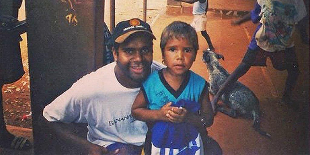 Then-Kangaroos star Byron Pickett with a young boy in the Northern Territory in the late 1990s. The boy, Jake Neade, now plays for Port Adelaide.