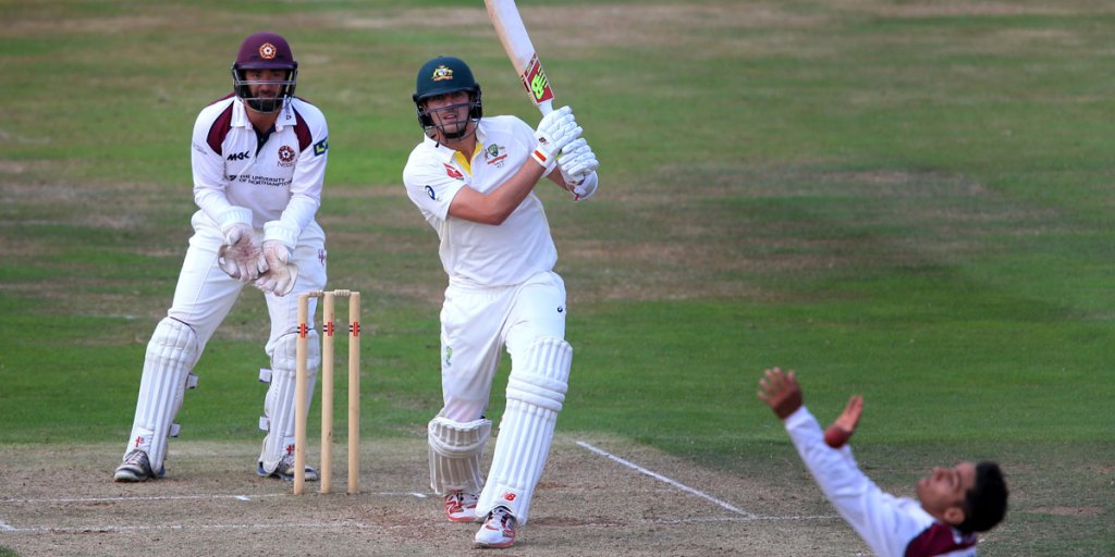 Australia batsman Pat Cummins drives the ball over the head of Northamptonshire bowler Saif Zaib.