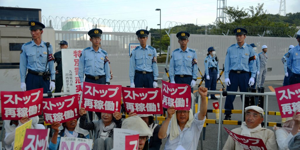 Police officers stand guard as protesters rally against restarting the nuclear reactor at the Kyushu Electric Power Sendai nuclear power plant. 