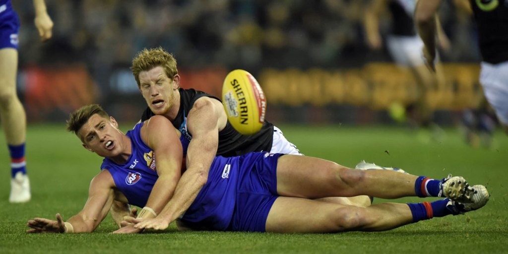 Michael Talia of the Western Bulldogs (left) is tackled by Port's Matthew Lobbe.